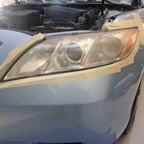 Sedan headlight before restoration, hazy and oxidized