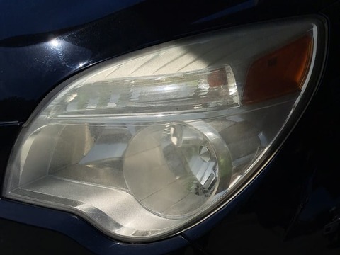 Sedan headlight before restoration, hazy and oxidized