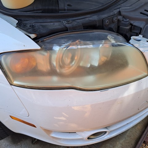 Sedan headlight before restoration, hazy and oxidized