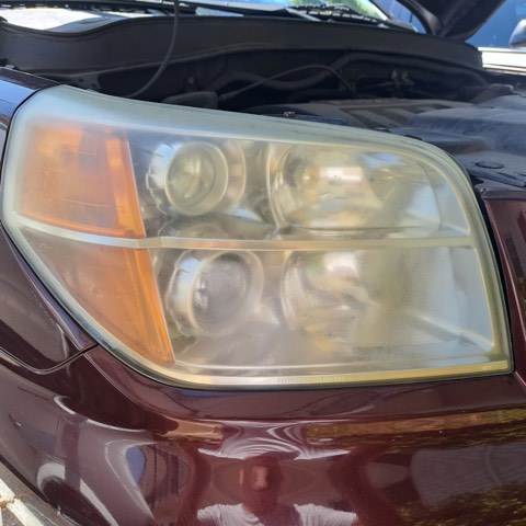 Sedan headlight before restoration, hazy and oxidized