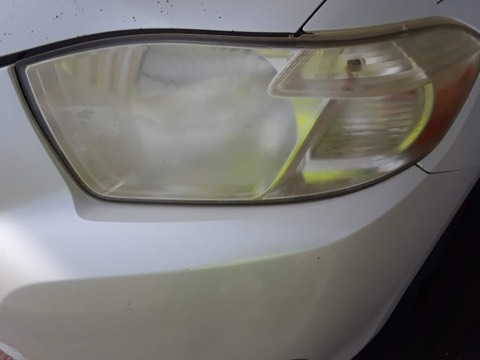 Sedan headlight before restoration, hazy and oxidized