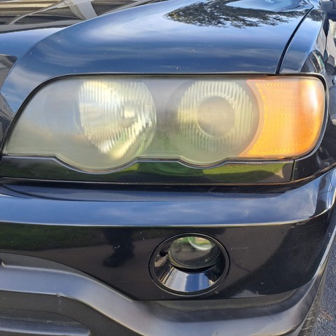 SUV headlight before restoration, hazy and oxidized
