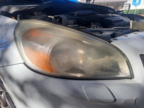 Sedan headlight before restoration, hazy and oxidized